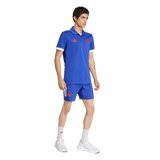 A man wears the adidas France FFR Home Supporters Replica Polo with matching shorts featuring red logos, white socks, and white athletic shoes against a plain background—ideal for passionate France Rugby fans.