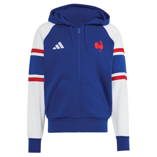 Discover the France FFR 26/27 Travel Full Zip Hoodie by adidas—a blue full-zip hoodie featuring white sleeves, red and blue stripe accents, two front pockets, and embroidered chest logos. This adidas piece is perfect for France Rugby fans who want sporty style and comfort.