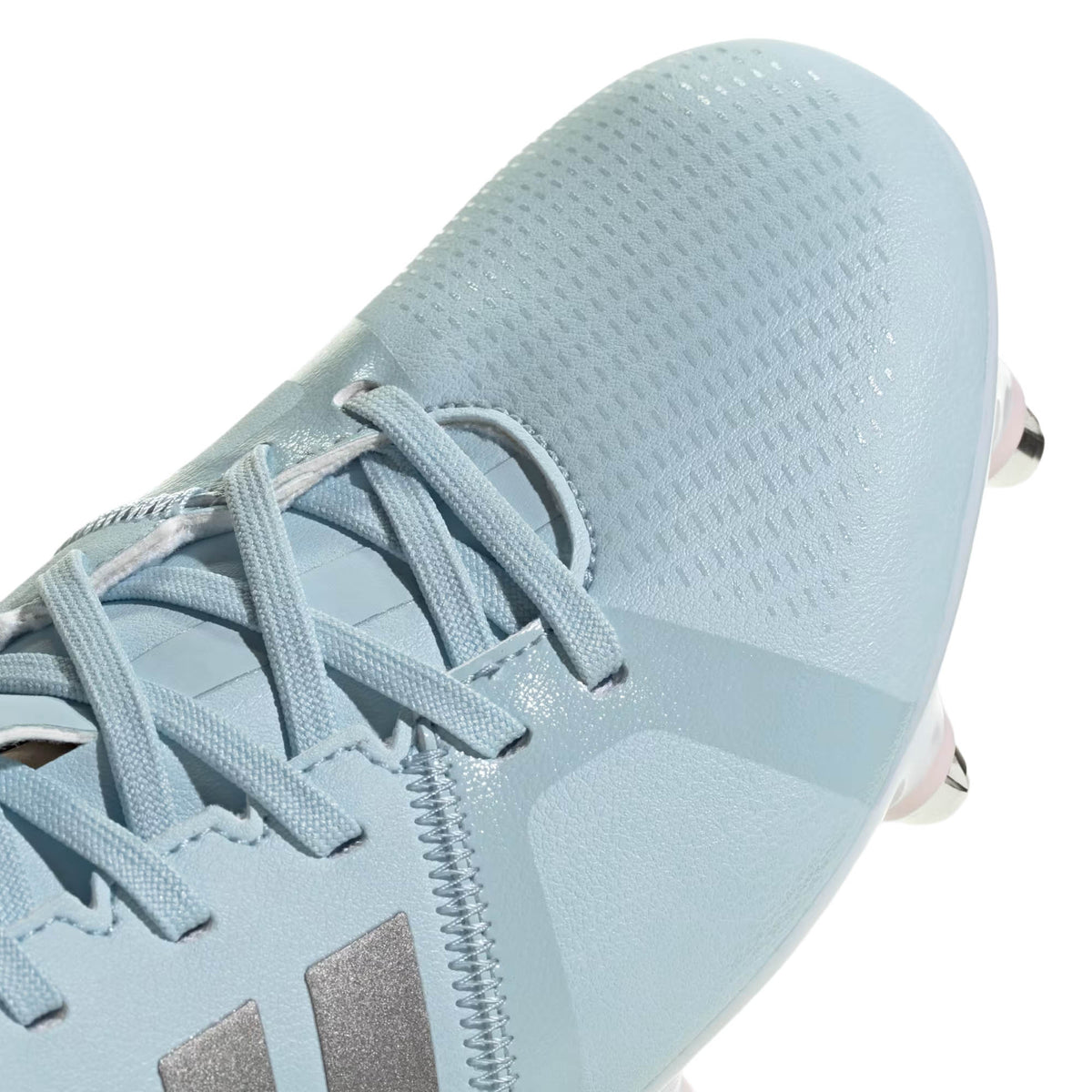 Close-up of the adidas RS-15 Avaglide Rise SG in Ice Blue/Iron/Pink, highlighting its laces, textured upper, and metal-tipped studs on the outsole—perfect for players seeking high-performance soft ground rugby boots.