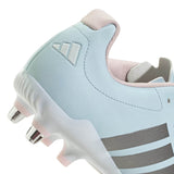 Close-up of the adidas RS-15 Avaglide Rise SG women’s rugby boot in Ice Blue with Iron stripes and Pink accents, featuring metal studs and a textured sole. This soft ground boot includes a padded collar and an embossed adidas logo on the heel.