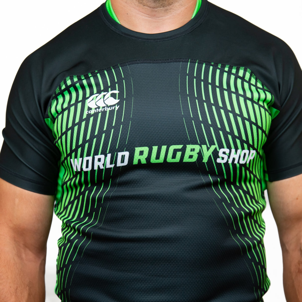 A person wearing a black and green Canterbury Elite Full Custom Sublimated Jersey - Mens by Teamatical, featuring a geometric pattern and branding.