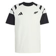 The All Blacks 26/27 Travel T-Shirt by adidas is a white and black short-sleeve shirt featuring a striking black fern and the adidas logo on the chest, along with bold black angled stripes on the shoulders—a classic look inspired by the iconic New Zealand rugby shirt.