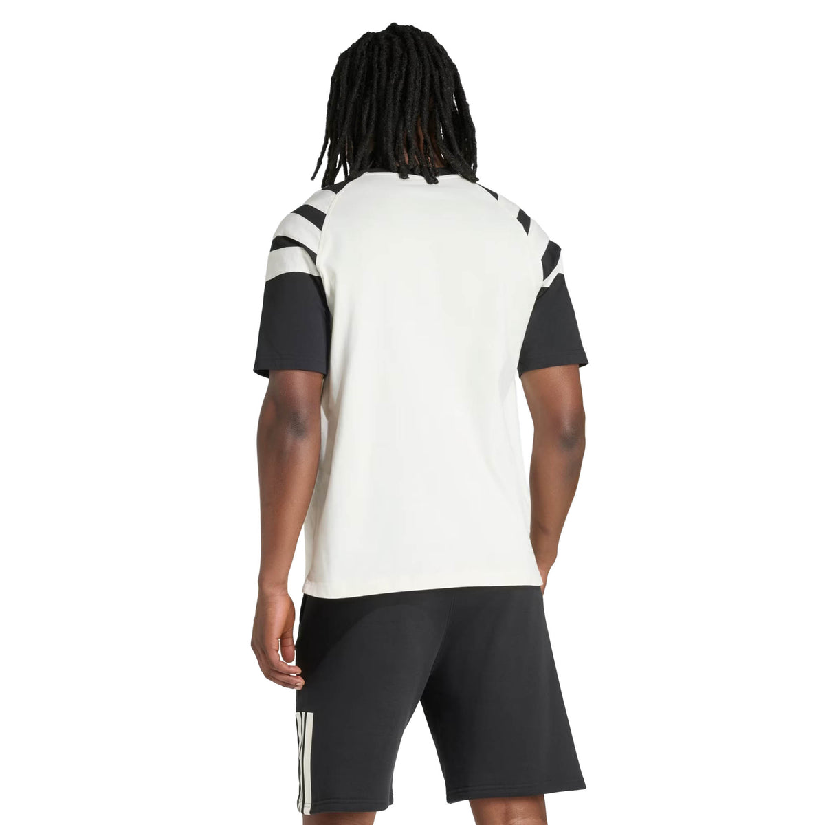 Wearing the All Blacks 26/27 Travel T-Shirt by adidas, a short-sleeve white and black rugby-style shirt with striped details, paired with matching black shorts, shown from the back.