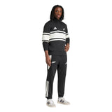 A person wearing the adidas All Blacks 26/27 Leisurewear 1/4 Zip Sweatshirt, posing against a plain white background.