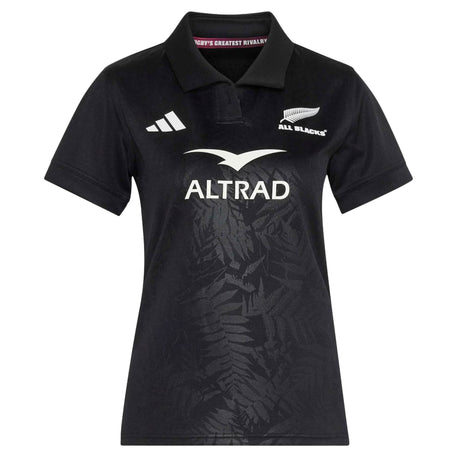 Introducing the adidas Women’s All Blacks Greatest Rivalry Replica Home Jersey—a black short-sleeve rugby jersey showcasing the iconic All Blacks logo, Altrad sponsor, and a subtle fern pattern on the front. Finished with a white adidas logo on the right chest, this replica jersey combines classic style with modern performance.