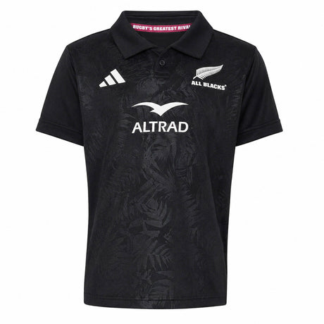 Youth-sized black rugby polo jersey from adidas with All Blacks and Altrad logos on the front, showcasing a subtle fern pattern and classic collar—an authentic Youth All Blacks Greatest Rivalry Replica Home Jersey inspired by New Zealand Rugby.