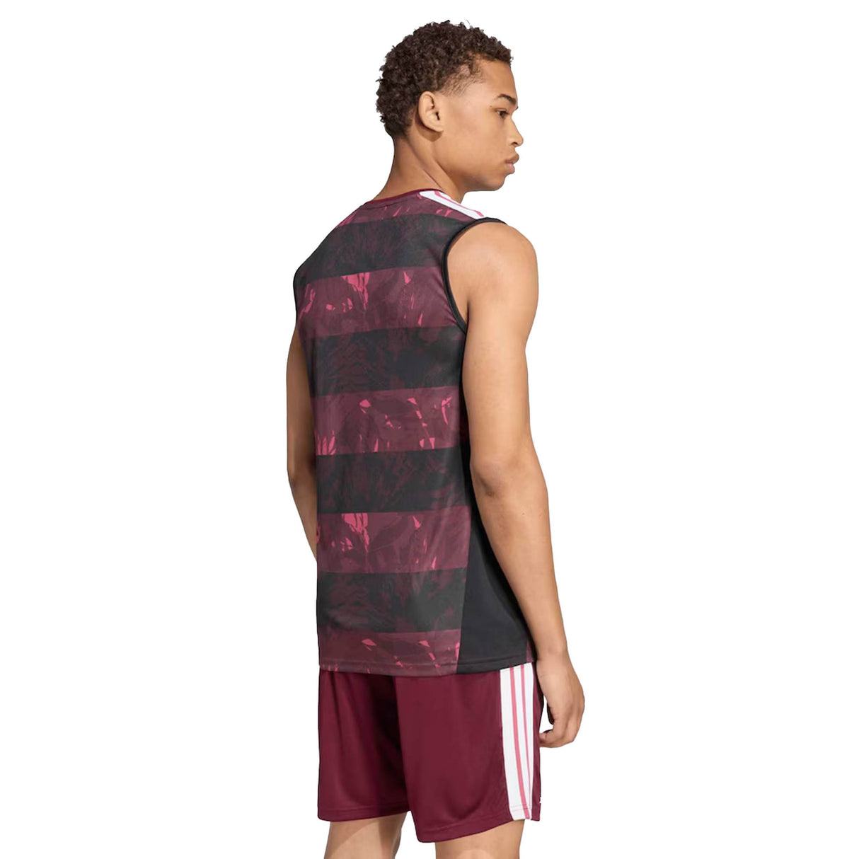 A person wearing an adidas All Blacks Greatest Rivalry Training Singlet, which is sleeveless and features a black and maroon pattern, along with maroon athletic shorts, is standing and facing away from the camera against a white background.