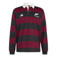 The All Blacks 26/27 Heritage LS Polo by adidas is a long-sleeve rugby shirt featuring wide maroon and black horizontal stripes, a crisp white collar, and embroidered logos—including adidas branding and the iconic All Blacks crest—celebrating New Zealand’s rich rugby heritage.