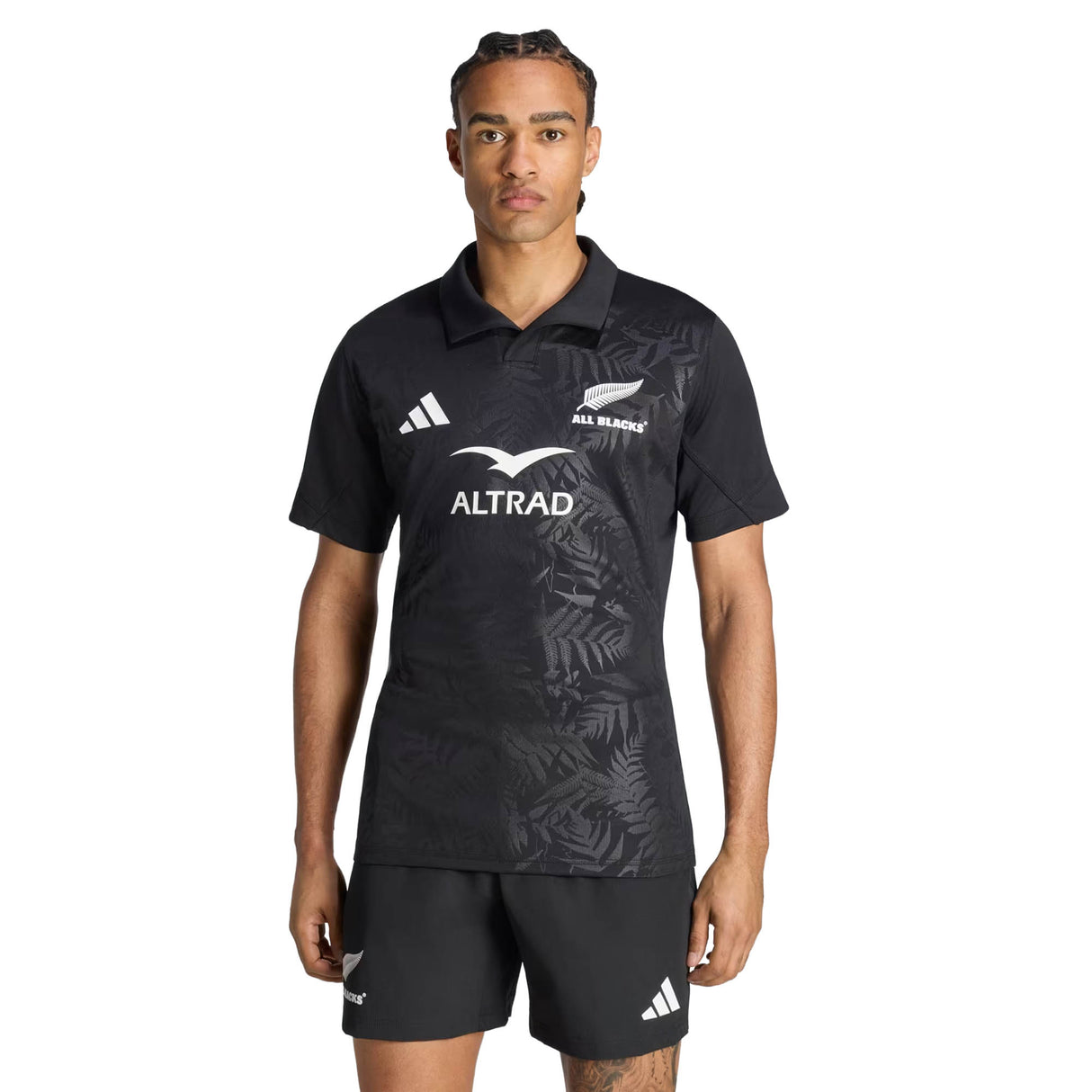 A person wearing the adidas All Blacks Greatest Rivalry Performance Home Jersey stands facing forward against a plain white background, paired with black shorts.