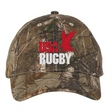 The USA Rugby Throwback Licensed Camo Cap - Realtree Xtra by EMB S&S Activewear features "USA RUGBY" text and a red eagle graphic, perfect for any fan of USA Rugby caps.