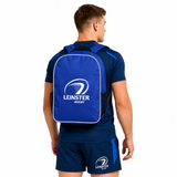 A man in blue athletic wear faces away, sporting the Castore Leinster Backpack 24/25 with the team logo and name printed in white.