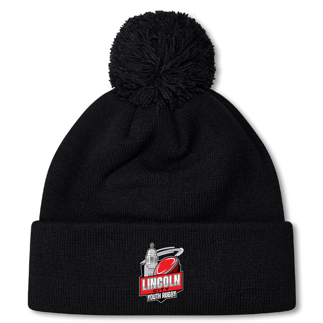 The Lincoln City Youth Rugby Pom Pom Beanie by EMB Canterbury is a black knit hat with a cozy fleece lining, bobble design, and an embroidered "Lincoln Youth Rugby" logo on the front cuff.