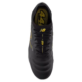 The New Balance 442 v2 Elite FG Wide Boots feature a top view of the black design with metallic gold accents, laces, a gold logo, and the "442" prominently displayed on the tongue.