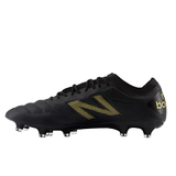 The New Balance 442 v2 Elite FG Wide Boots in Black/Metallic Gold are premium black soccer cleats with yellow studs, ideal for firm ground. They feature a textured surface and lace-up design for optimal performance.