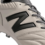 Close-up of a New Balance Wide 442 V2 Pro FG athletic shoe in Concrete, Grey Matter, and Blacktop color scheme with gray laces, firm ground studs, and a large black "N" logo on the side. The premium leather rugby cleat design ensures durability and comfort.