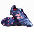 A pair of New Balance 442 v2 Pro FG Wide Boots in Navy/Energy Red, featuring wide fit, studs, and one boot upright while the other lies on its side.
