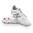 The New Balance Wide 442 v2 Pro Synthetic FG in White/Silver features prominent New Balance branding on the side, orange studs for firm ground, and a sleek white exterior.