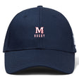 The San Joaquin Memorial Flexfit Drill Cap by EMB Canterbury is a navy blue cap with "M Rugby" embroidered in red and white on the front, featuring a classic curved brim design.