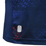 Close-up of the USA Rugby 25/26 Away Replica Jersey by Macron, featuring navy blue fabric with red and blue star patterns and a small “Official Licensed Product” and “Eco” label near the bottom hem.