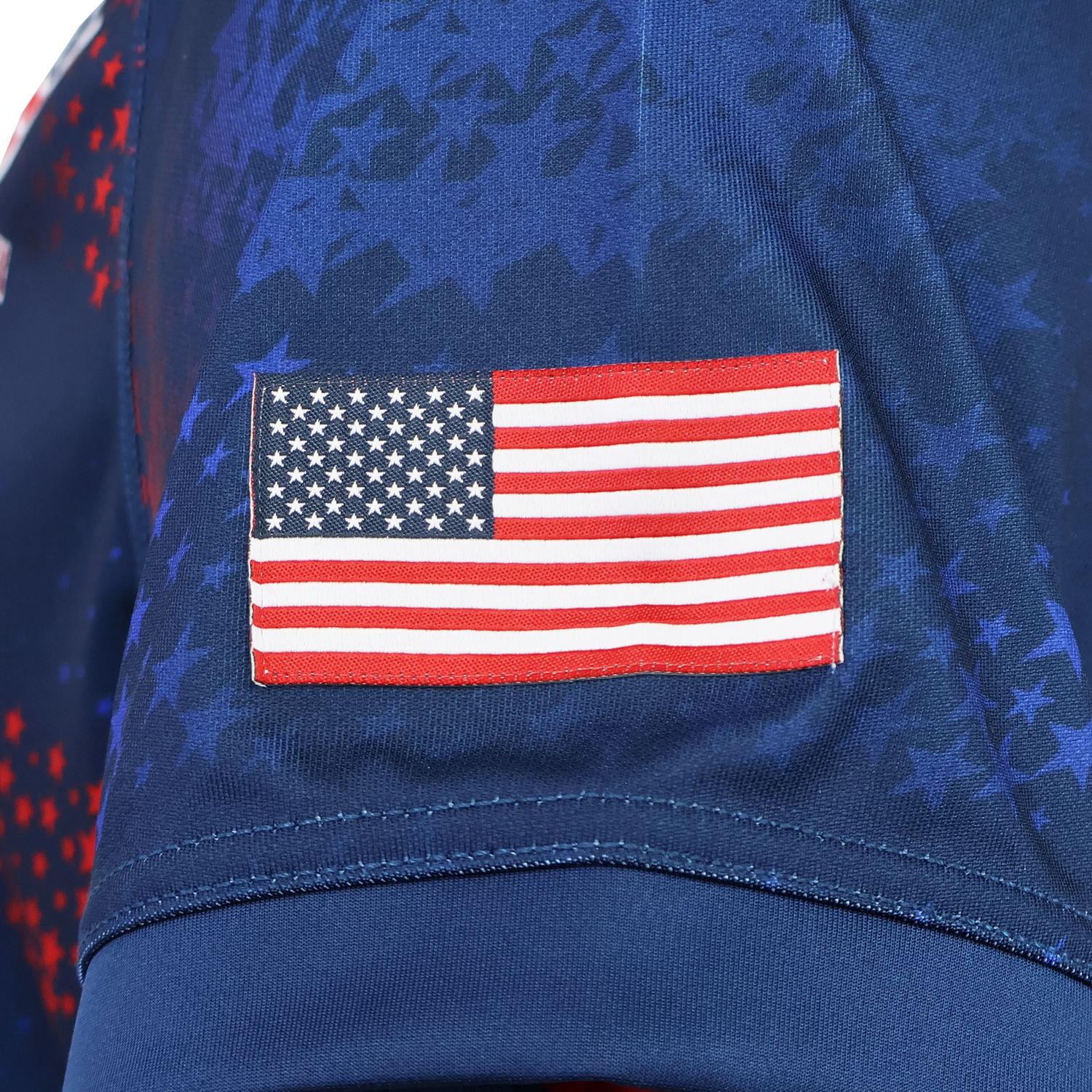 Close-up of an embroidered American flag patch on the sleeve of the USA Rugby 25/26 Away Replica Jersey by Macron, featuring a patriotic star pattern.