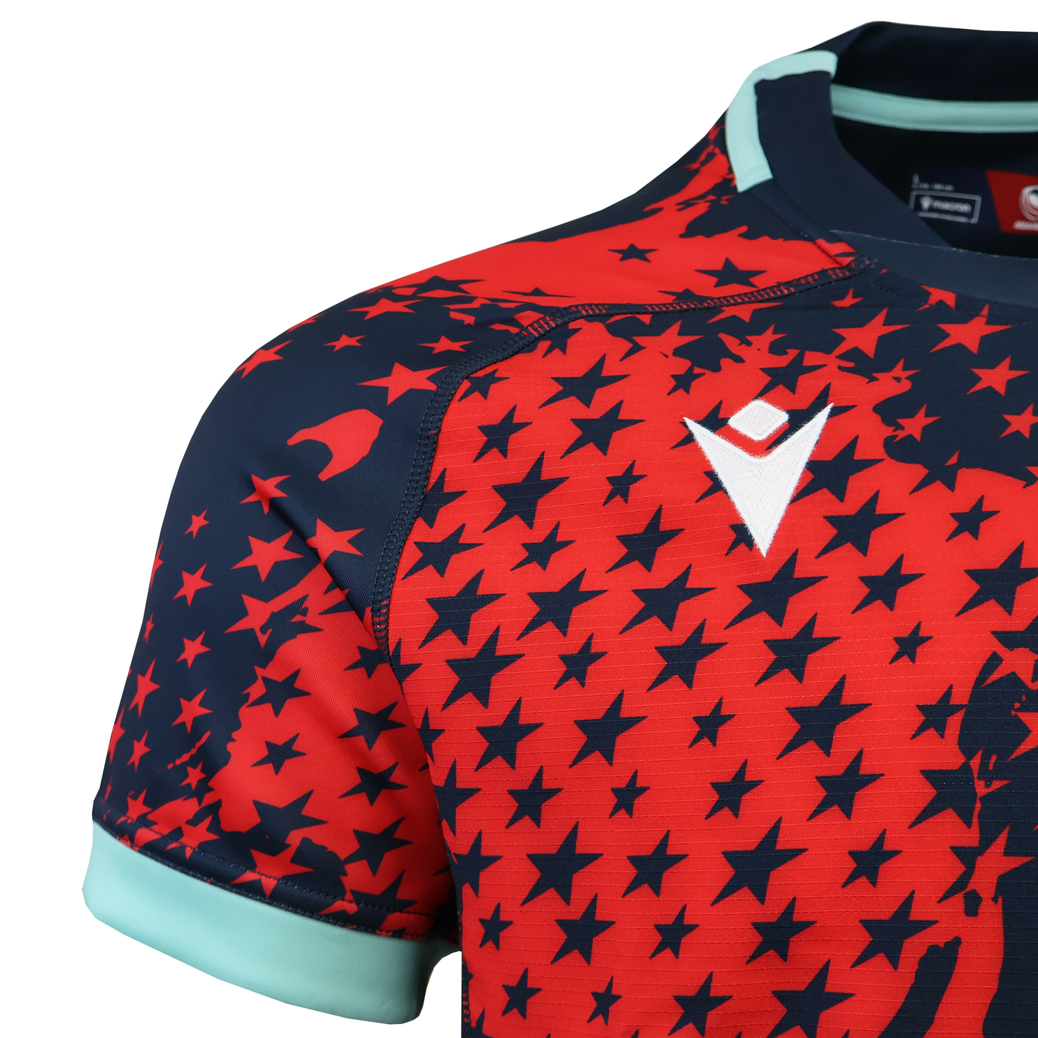 Close-up of the USA Rugby 25/26 Training Rugby Jersey #1 by Macron, featuring a pro-level red and navy star pattern, light blue sleeve trim, and a white chest logo—ideal for dedicated USA Rugby fans.