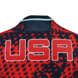 Back of the USA Rugby 25/26 Training Rugby Jersey #1 by Macron in red and navy with a star pattern and bold "USA" text—perfect for showing your support or training like a pro.