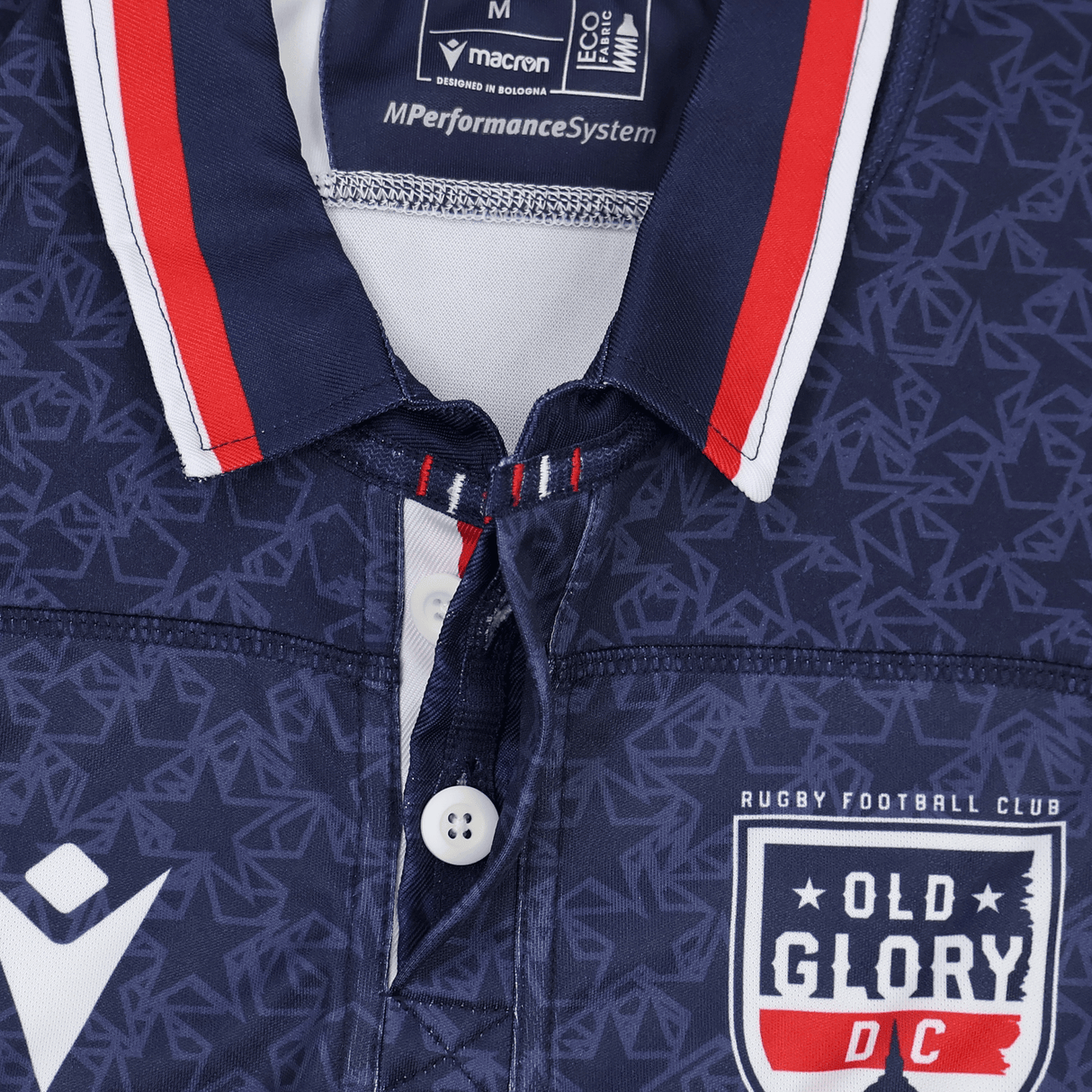 Close-up of the Old Glory DC MLR 25/26 Replica Home Jersey by Macron, featuring a navy geometric pattern, buttons, and the club's chest logo—a true replica rugby jersey from Macron.