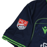 Close-up of the Seattle Seawolves MLR 25/26 Replica Home Jersey by Macron, featuring a navy sleeve with red and white Major League Rugby logo patch and green cuff trim.
