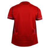 The Wales WRWC25 Replica Home Jersey by Macron is a red short-sleeve athletic shirt, shown from the back, with subtle panel details and reflective piping—ideal for Welsh rugby fans.