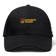The Norwich University Women's Rugby Flexfit Drill Cap by EMB Canterbury features a black flexfit design with "Women's Rugby" and a maroon and gold embroidered "N" logo on the front.