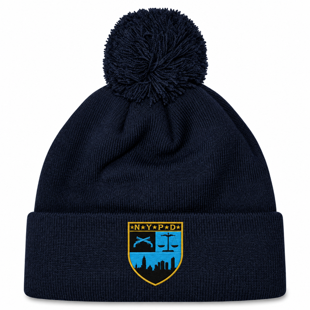Navy blue cuffed knit New York Police Dept. Rugby Pom Pom Beanie by Canterbury with a pom-pom on top and an NYPD emblem patch on the front.