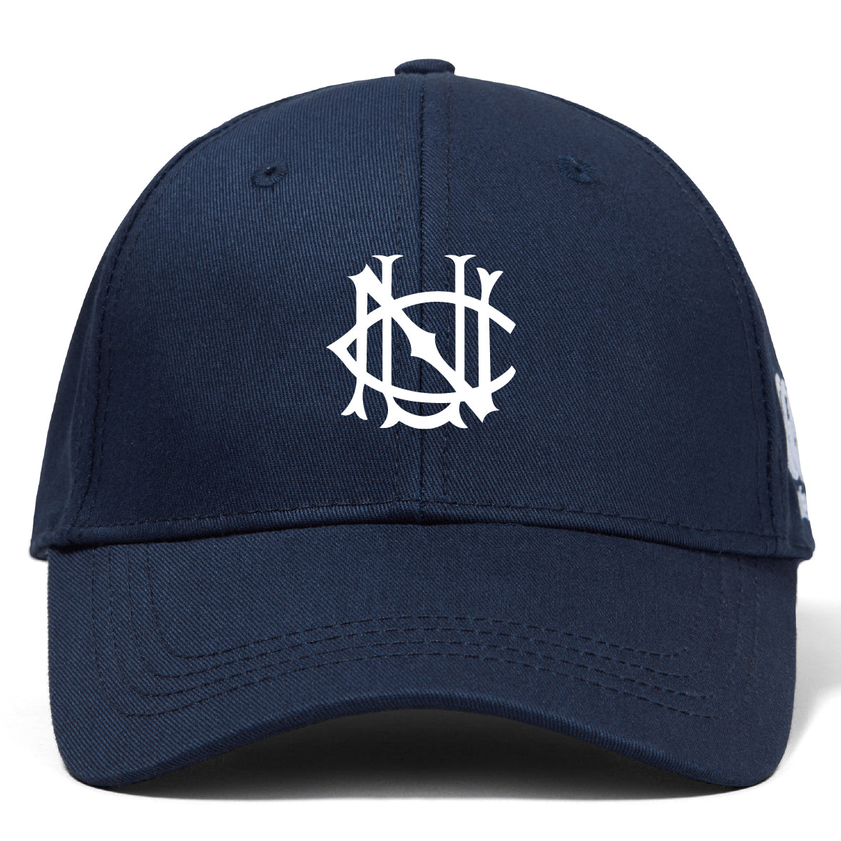 The UNC Rugby Flexfit Drill Cap by EMB Canterbury is a navy blue curved brim cap with a white embroidered stylized overlapping NS logo on the front panel.