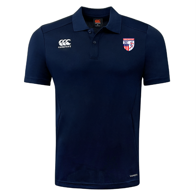 The Naperville Warriors Club Dry Polo by EMB Canterbury is a navy short-sleeve polo with a collar, Vapodri Technology for breathability, Canterbury logo on the right chest, and a red, white, and blue shield emblem on the left chest.