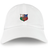 The EMB S&S Activewear NYC British and Irish Selects Adult Low-Profile Cotton Twill Dad Cap features a white design with a colorful embroidered shield logo and "NYC British & Irish Select Rugby" on the front.