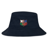 The NYC British and Irish Selects Crusher Bucket Cap by EMB S&S Activewear is a navy cotton twill bucket hat with an embroidered shield patch reading "NYC Welsh & Irish Select Rugby" in red, white, and green for stylish sun protection.