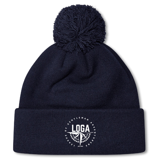 Stay warm on chilly days with the League of Gentleman Adventurers Pom Pom Beanie by EMB Canterbury—a navy blue, fleece-lined rugby hat with a folded brim, white "LOGA" logo, and pom-pom on top.