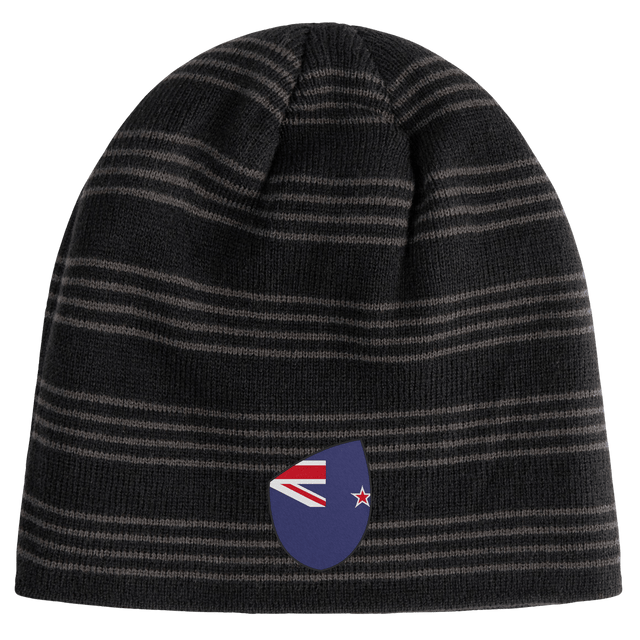 The New Zealand Shield Beanie from EMB Canterbury features black and gray stripes with a small shield displaying a stylized New Zealand flag.