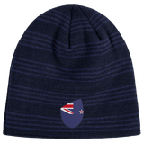The New Zealand Shield Beanie by EMB Canterbury is a dark blue knit with subtle stripes and an emblem reminiscent of a stylized flag, featuring a red and white design on a blue background.