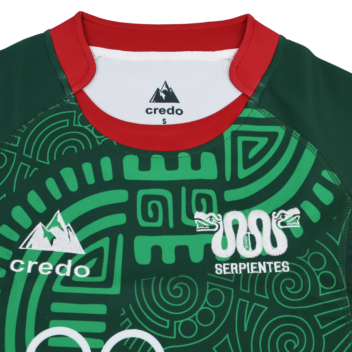The Las Serpientes Mexico Rugby Replica Jersey by Credo Rugby features a green color, red collar, abstract geometric patterns, "Serpientes" text, twin snake logos, and authentic Credo Rugby branding—designed to honor Mexico’s rugby team.