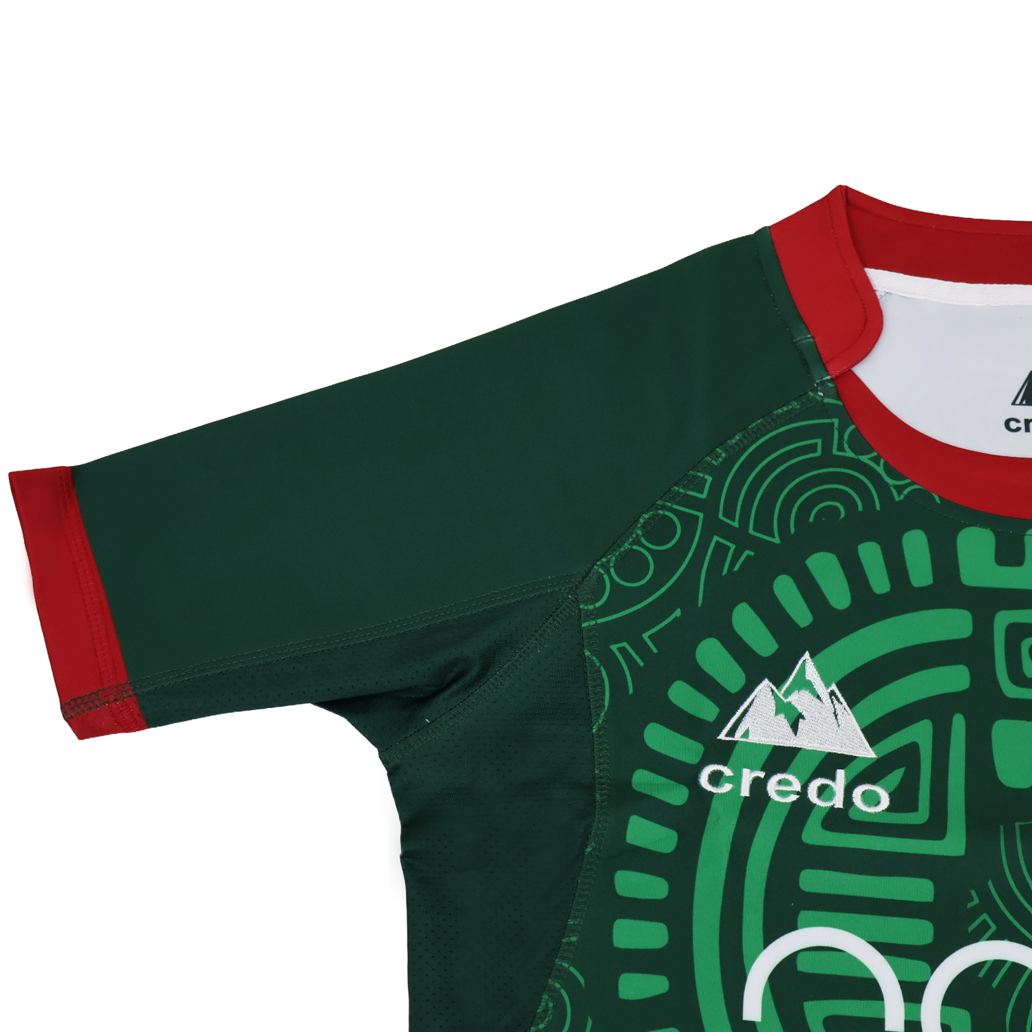 The Las Serpientes Mexico Rugby Replica Jersey by Credo Rugby features a green geometric pattern, red collar and sleeve trim, and the Credo Rugby logo with mountain graphic—boldly inspired by the iconic original jersey.
