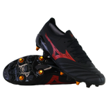 A pair of Mizuno Neo IV Beta Elite AG football boots in Black/Morelia 40th Red/Black, with one shoe upright and the other on its side showing gold studs and the sole.