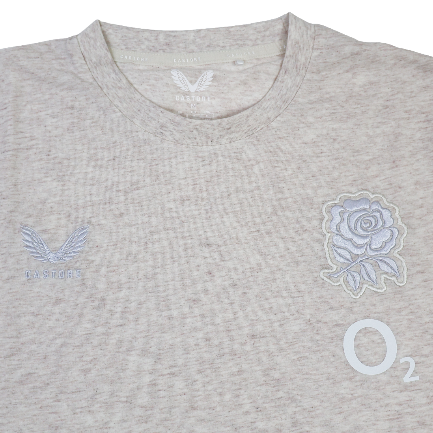 The England 26/27 Off-Pitch Tee by Castore is a light beige t-shirt with the England Rugby tee logo, an embroidered rose emblem, and the O2 logo on the front—ideal for off-pitch wear.