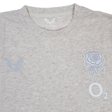 The England 26/27 Off-Pitch Tee by Castore is a light beige t-shirt with the England Rugby tee logo, an embroidered rose emblem, and the O2 logo on the front—ideal for off-pitch wear.
