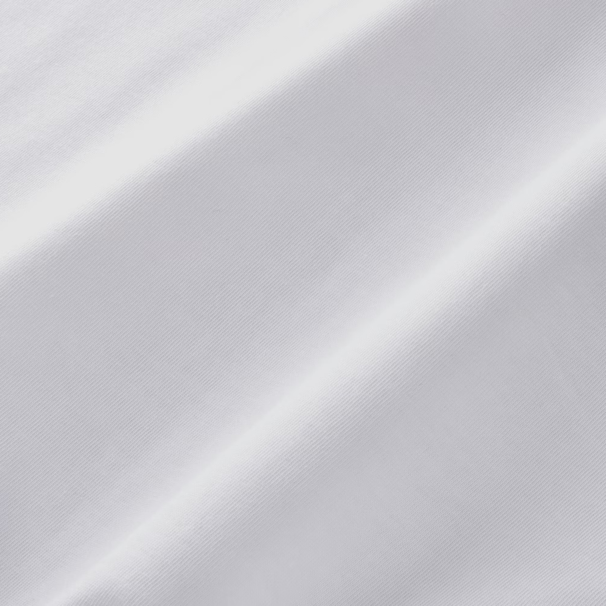 Close-up of plain white fabric with diagonal weave and soft lighting, highlighting its texture—perfect for the England 26/27 Off-Pitch Tee by Castore.