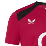 Close-up of the red England 26/27 Performance Training Tee by Castore, showing black shoulder detail, white Castore logo, partial number/logo beneath, and crafted with moisture-wicking technology.