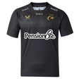 The Saracens 26/27 Replica Home Jersey by Castore is a sleek black short-sleeved jersey featuring gold logos and stars, “PensionBee” sponsor text on the front, and “StoneX” branding on the chest and shoulders.