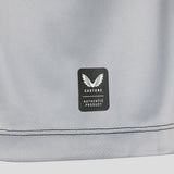 A close-up of gray fabric from the Harlequins 26/27 Replica Home Jersey by Castore, featuring a label with the white winged Castore logo and the text “Castore Authentic Product.” Two lines of stitching can be seen near the fabric’s edge.
