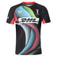 The Castore Harlequins 26/27 Replica Third Jersey features a black base with a vibrant swirl pattern, the DHL logo prominently displayed in the center, and both Castore and Harlequins logos on the chest. Red accents highlight the sleeves, while unique glow-in-the-dark details make this jersey—modeled after the iconic Big Game 18 Shirt—a standout choice for bold style on and off the pitch.