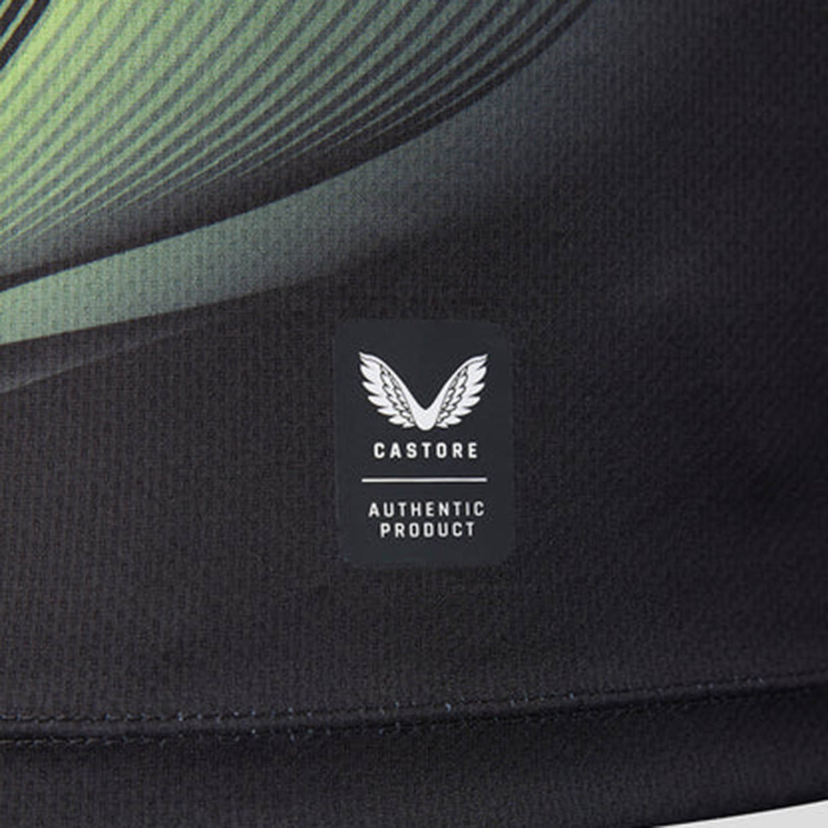 Close-up of a black fabric from the Harlequins 26/27 Replica Third Jersey by Castore, featuring the Castore logo and an “Authentic Product” label with a white wing emblem—showcasing the intricate detailing of this official jersey.