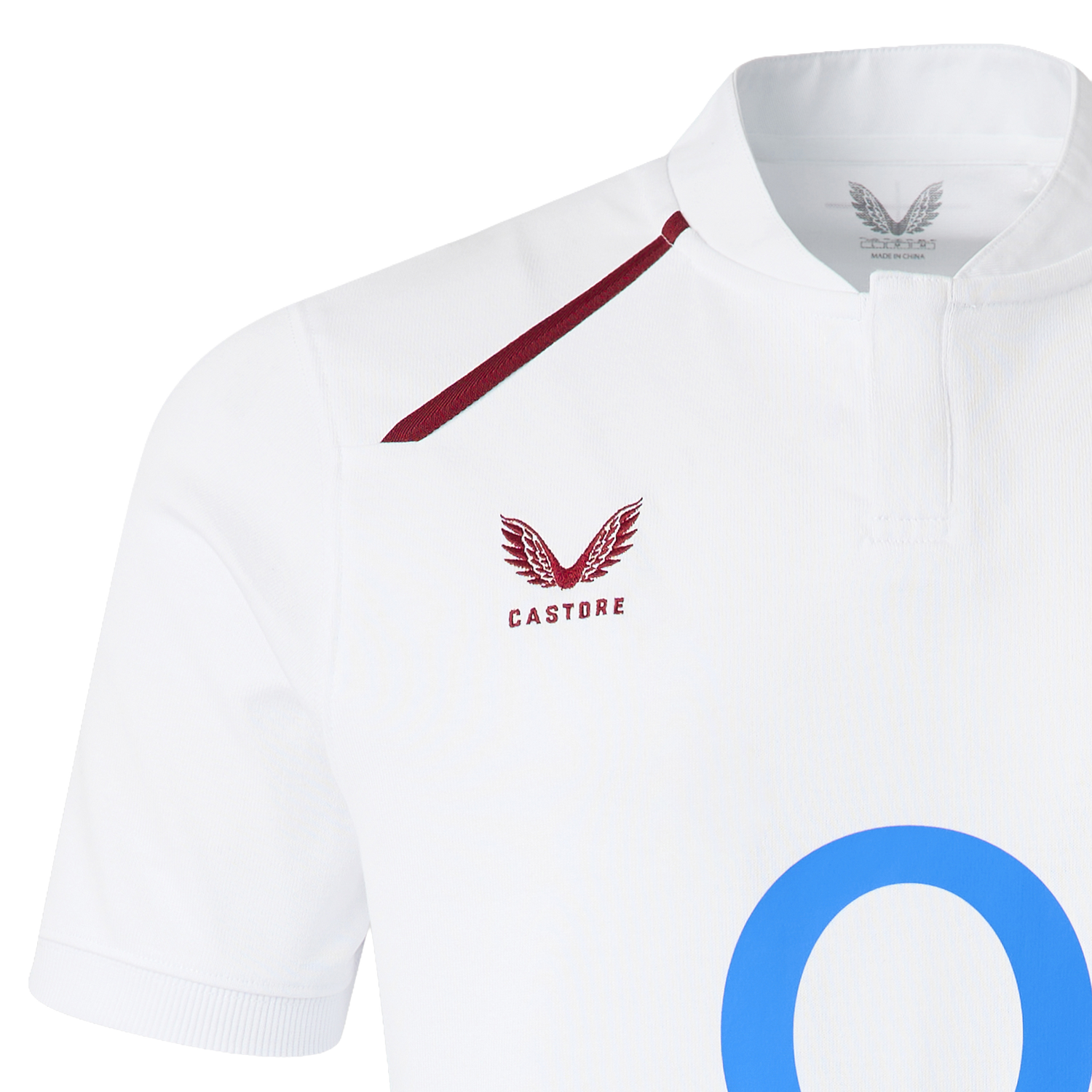 Close-up of the England 26/27 Classic Home Jersey by Castore, featuring a maroon winged logo, "Castore" text on the chest, blue "O" detailing, and a buttoned collar for a fresh update on the iconic look.